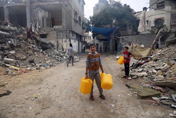 Un garçon va chercher de l’eau dans un quartier bombardé de Gaza.