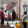 Unos niños recogen agua en la Franja de Gaza.