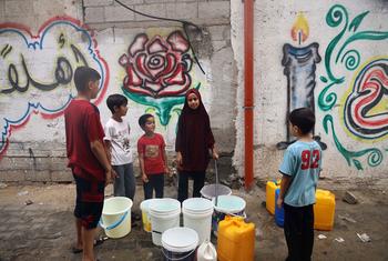 أطفال فلسطينيون في قطاع غزة، منهم مريم، يستعدون لمهمتهم اليومية لجلب المياه من مكان بعيد عن منازلهم. تتمنى مريم أن يتوقف إطلاق النار لتعود إلى مدرستها وما كانت عليه حياتها من قبل.