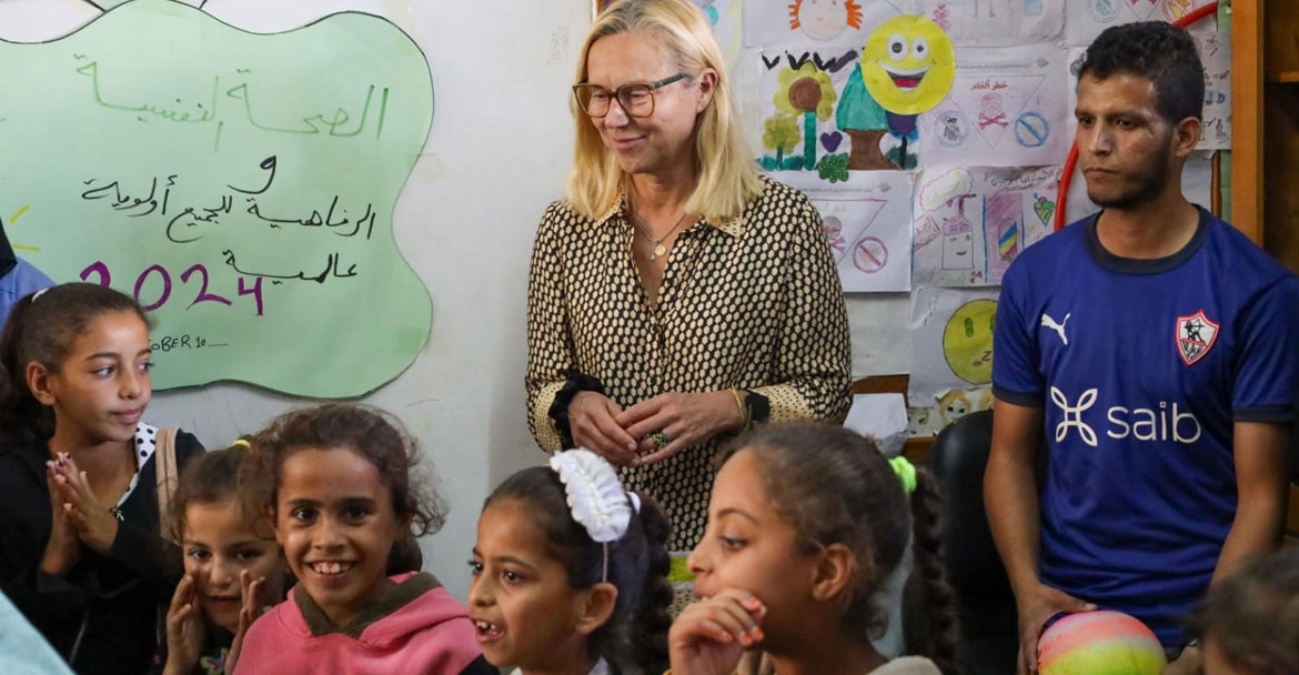 زارت المسؤولة الأمم المتحدة سيغريد كاغ مدرسة النصيرات الإعدادية للبنين في غزة برفقة مجموعة من الأطفال الفلسطينيين في فصل دراسي.