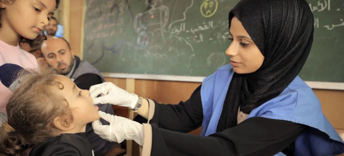 Сотрудница БАПОР проводит вакцинацию ребенка в Газе в ноябре 2024 года.