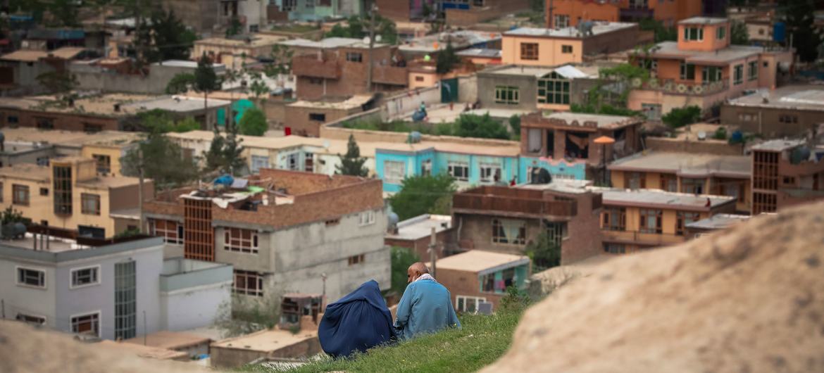 شخصان ينظران عبر إحدى ضواحي العاصمة الأفغانية كابول.