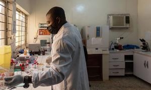 A doctor reviews a sample at a microbiology laboratory in a teaching hospital in Nigeria.