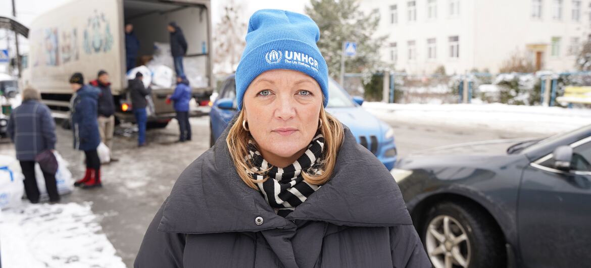 Elisabeth Arnsdorf Haslund, vêtue d'un chapeau du HCR, debout devant un camion lors d'une distribution d'aide d'hiver en Ukraine.