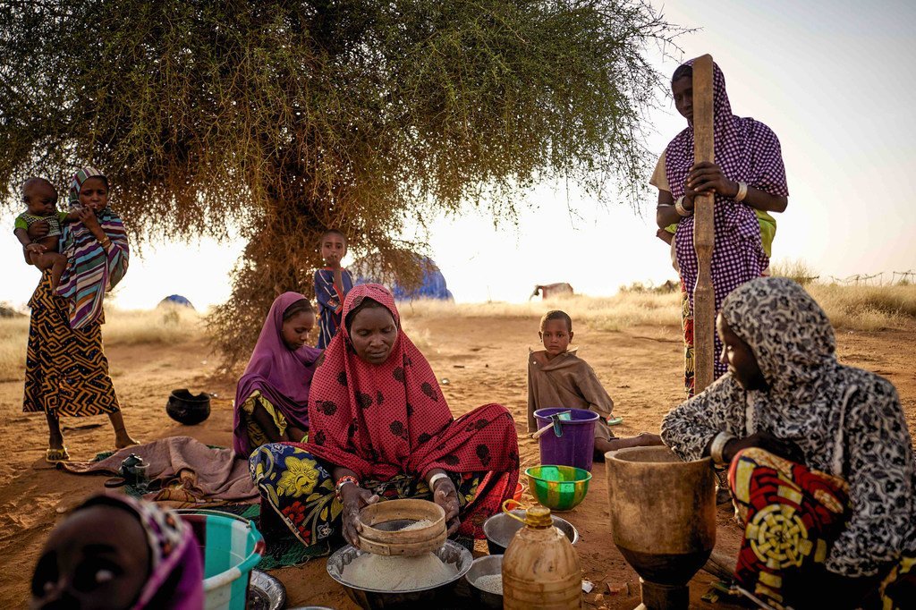 Sahel : des femmes déplacées préparent de la nourriture dans un camp informel à Bagoundié, au Mali.
