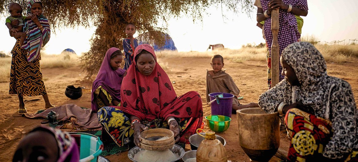 Yerinden edilmiş kadınlar, Mali'nin Bagoundié kentindeki resmi olmayan bir kampta yemek hazırlıyor.