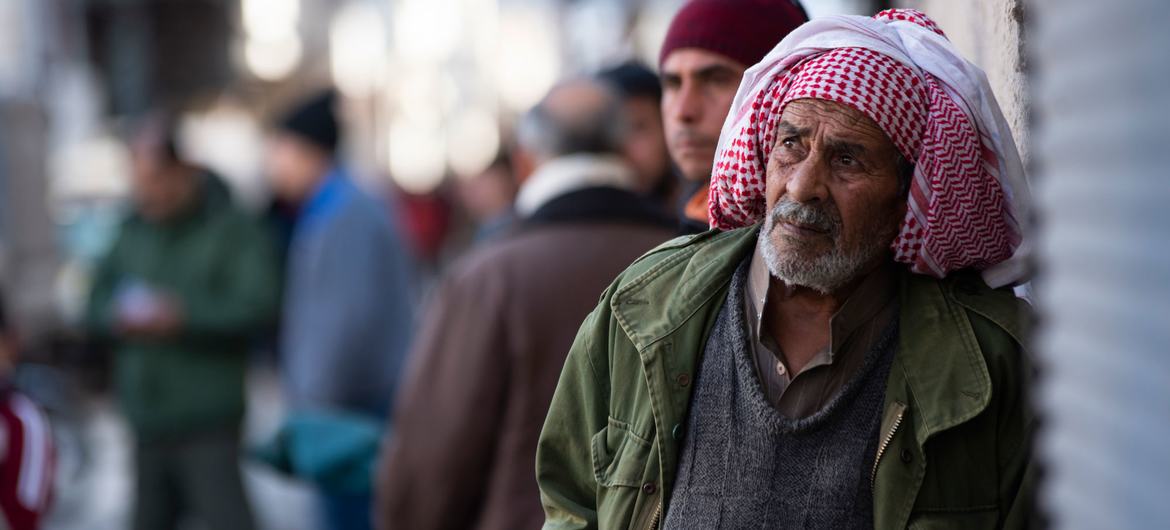 A man watches the recovery of the bodies of his relatives from under the rubble in Jableh district in northwestern Syria. 