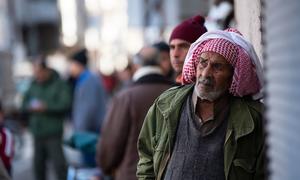 A man watches the recovery of the bodies of his relatives from under the rubble in Jableh district in northwestern Syria. 