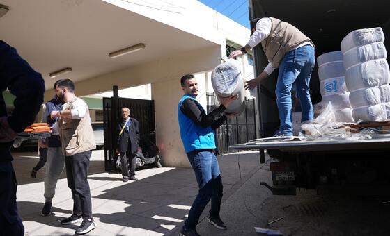 联合国工作人员在黎巴嫩南部西顿的一个避难所向流离失所家庭分发援助物品。