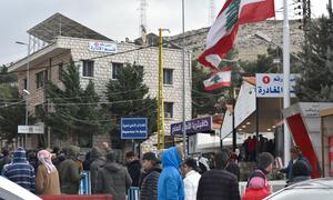 A crowd of people, including men, women, and children, gather at the Masnaa border crossing in Lebanon, waiting to enter Syria to escape Israeli bombing.
