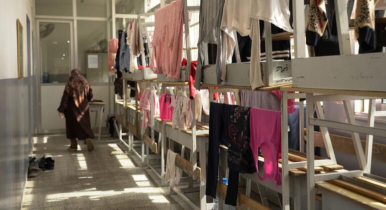 Mwanamke aliyevaa hijab anatembea katika darasa la shule moja huko Beirut ambayo imebadilishwa kuwa makao ya familia za wakimbizi.