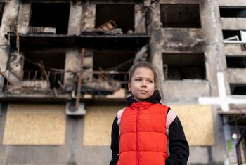 Une fillette de huit ans se tient devant un immeuble résidentiel bombardé à Dobropillia, en Ukraine.
