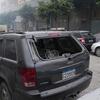 Un SUV Jeep gris endommagé, avec sa vitre arrière brisée et des débris éparpillés dans la rue à Beyrouth, au Liban, à la suite de frappes aériennes.