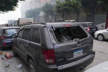 Un SUV Jeep gris endommagé, avec sa vitre arrière brisée et des débris éparpillés dans la rue à Beyrouth, au Liban, à la suite de frappes aériennes.