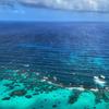 Vista aérea de la Reserva de la Biosfera Seaflower en Providencia, Colombia, que muestra las profundas aguas azules del océano que se encuentran con las aguas turquesas poco profundas sobre un arrecife de coral.