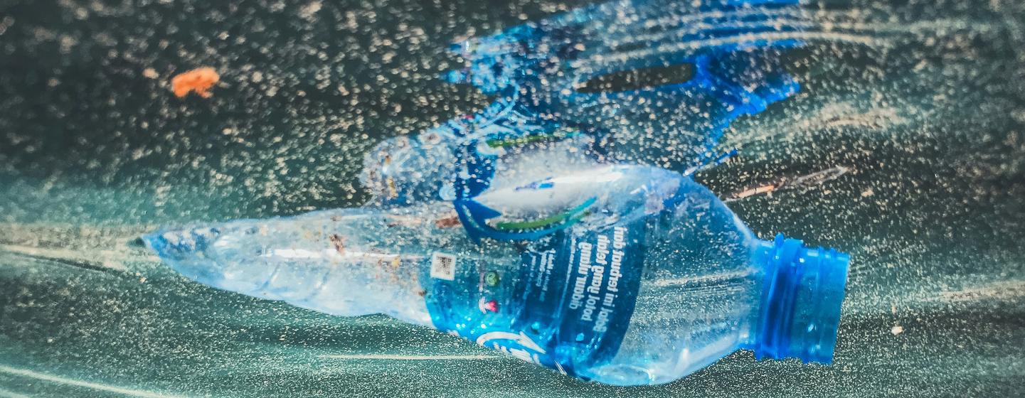 Una botella de agua de plástico flota en la superficie del agua en Indonesia.