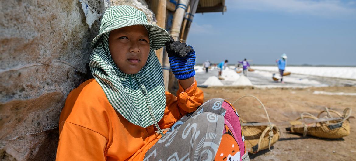 A young boy in Thailand takes a break while working in intense heat as a labourer. A young boy in Thailand takes a break while working in intense heat as a labourer.