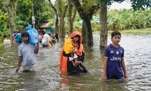 People wading through flood waters in search of shelter in Feni following catastrophic flooding that displaced five million people in southeastern Bangladesh in August 2024. (file)