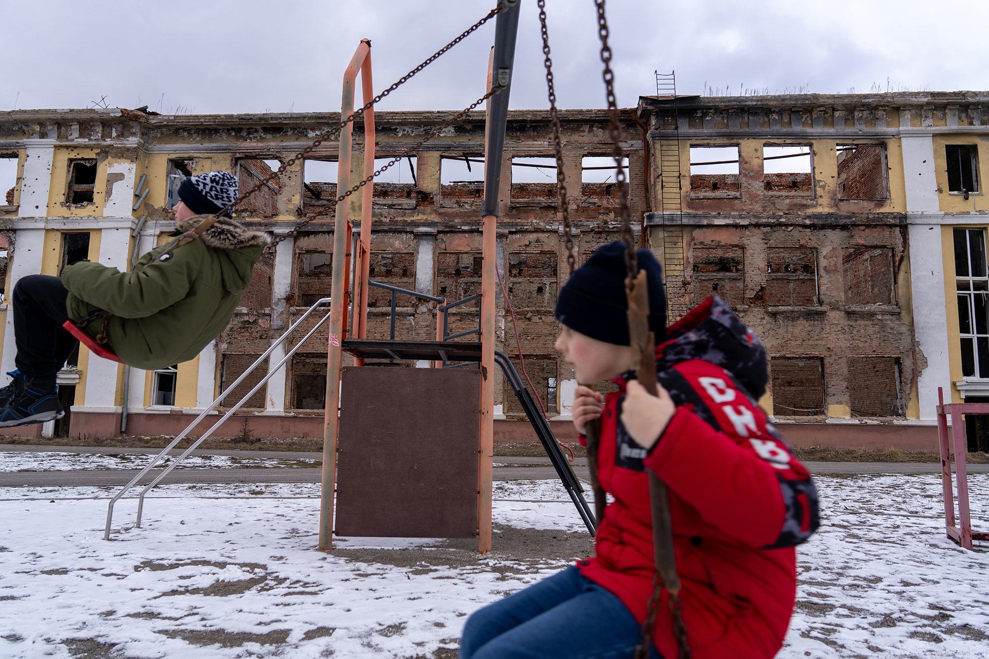 Des garçons jouent au milieu des ruines d'une école à Kharkiv, en Ukraine.