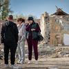 Des gens visitent un site du village de Hroza, en Ukraine, où des civils sont morts dans une frappe de missile.