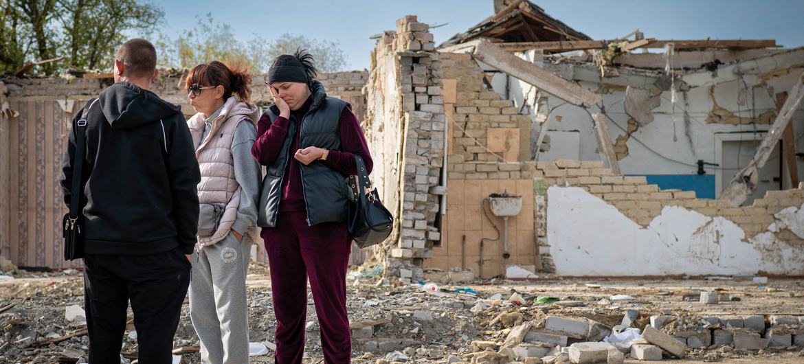Pessoas visitam um local na vila de Hroza onde civis morreram em um ataque de míssil