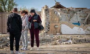 Pessoas visitam um local na vila de Hroza onde civis morreram em um ataque de míssil