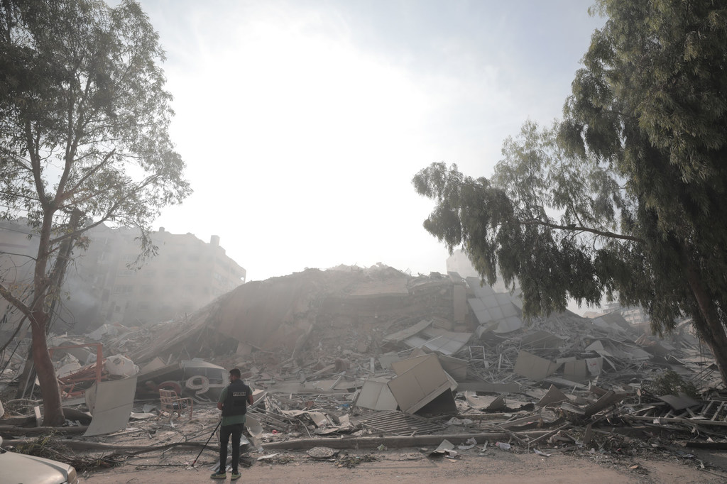 Un homme regarde un bâtiment effondré à Gaza.