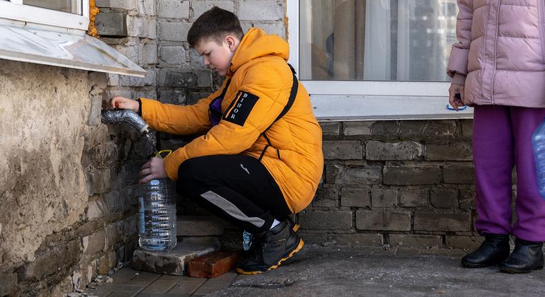 Un niño recoge agua potable en una escuela de la región de Donetsk, Ucrania.