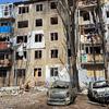 Immeuble d'appartements endommagé avec des voitures incendiées devant à Mykolaïv, en Ukraine.