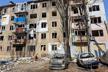 Immeuble d'appartements endommagé avec des voitures incendiées devant à Mykolaïv, en Ukraine.