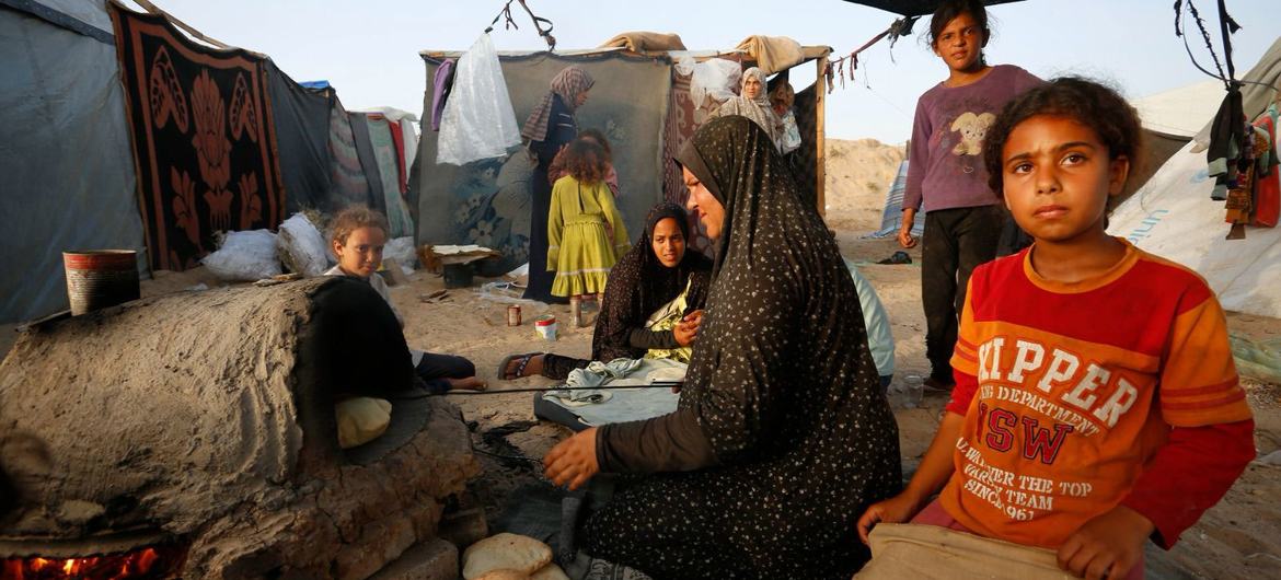 Uma mulher assa pão em um forno na Faixa de Gaza