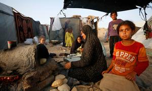 A woman cooks bread in an oven in the Gaza Strip.