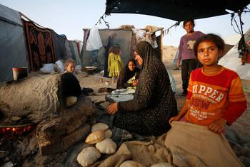 A woman cooks bread in an oven in the Gaza Strip.
