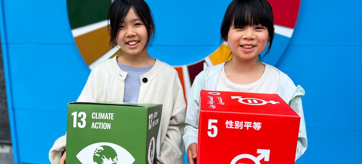 Kaneko Sayaka (left) and her sister hold up displays promoting the SDGs. Kaneko Sayaka (left) and her sister hold up displays promoting the SDGs.