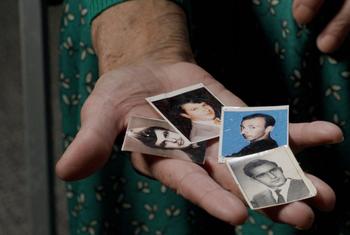 Kada Hotić holds photographs of her son, husband, and two brothers, who were lost in the Srebrenica genocide.