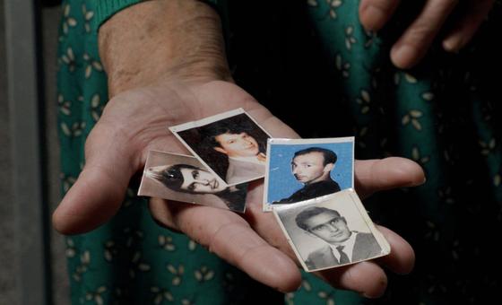 Kada Hotić holds photographs of her son, husband, and two brothers, who were lost in the Srebrenica genocide.