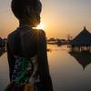 在南苏丹琼莱州，一名女孩看着被淹没的房屋。
