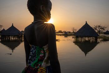 在南苏丹琼莱州，一名女孩看着被淹没的房屋。