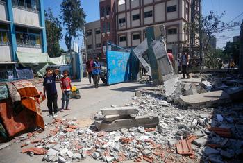 Varias personas examinan los daños causados por el bombardeo de una escuela en el centro de Gaza.
