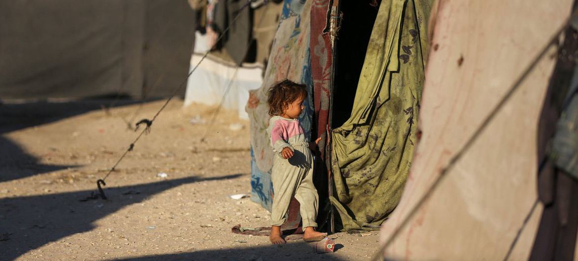 Un niño entra a la tienda de campaña en la que vive su familia desplazada en Gaza.