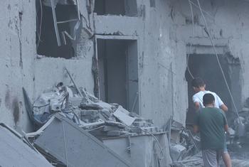 Two men approach a building in central Gaza which was reportedly struck by missiles.