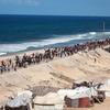 Des milliers de personnes déplacées marchent le long de la côte à Gaza.
