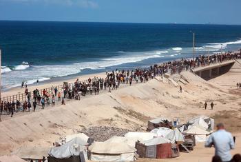Des milliers de personnes déplacées marchent le long de la côte à Gaza.
