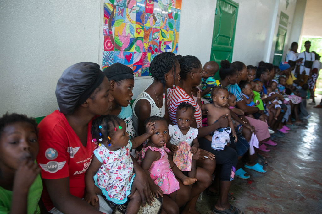 Des femmes et leurs enfants attendent dans une clinique mobile soutenue par l'UNICEF à Port-au-Prince, en Haïti.