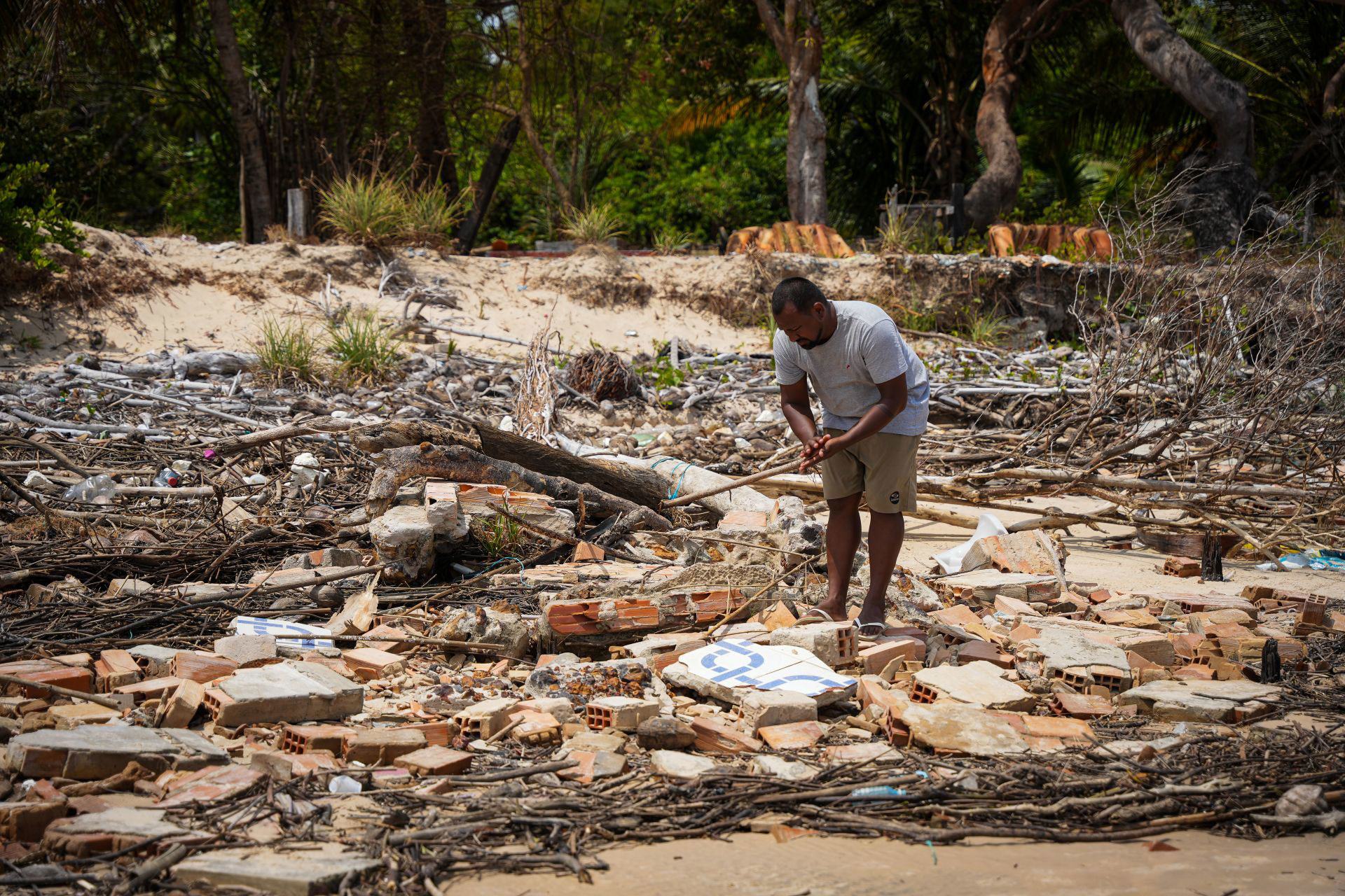 Jhonny, le fils d’Ivanil, fouille les décombres des maisons détruites.
