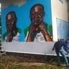 OIM apoia instalação de pinturas murais com citações de migrantes alertando sobre os perigos