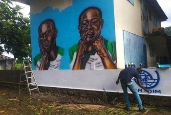 OIM apoia instalação de pinturas murais com citações de migrantes alertando sobre os perigos