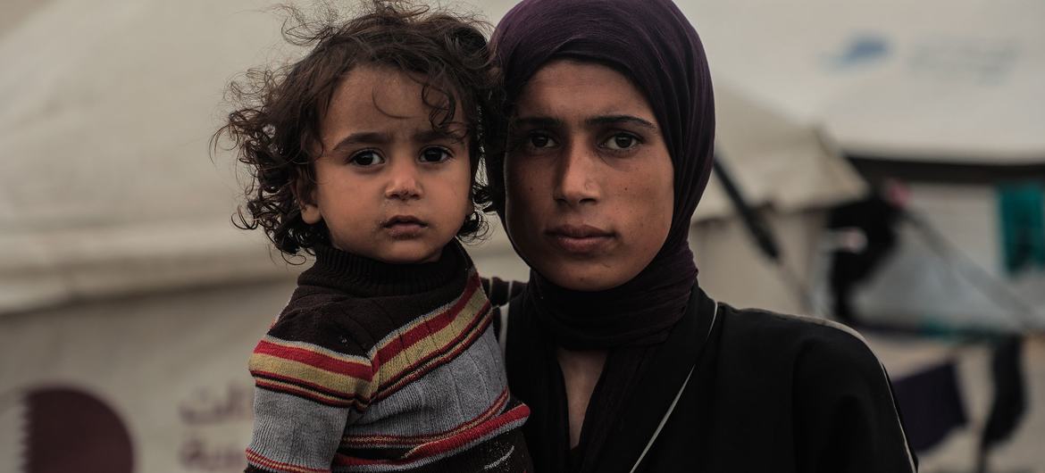 أم فلسطينية وابنتها في مخيم مؤقت للنازحين في مدينة غزة تواجهان برد الشتاء.