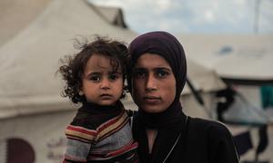Una mujer palestina y su hijo frente a la tienda en la que viven en la ciudad de Gaza.