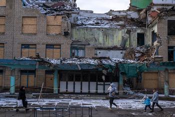 Des piétons passent devant des bâtiments détruits à Kurakhove, en Ukraine.